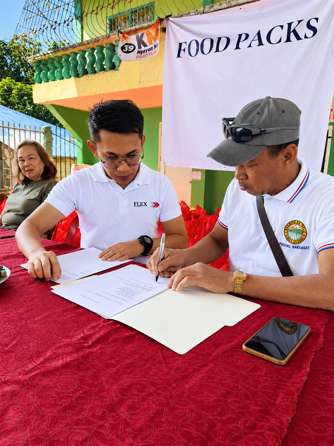 A Flex team member signing off with barangay leadership